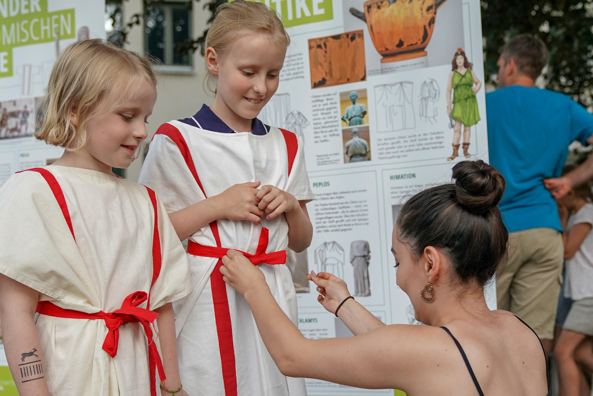 Gut gewandet: Kinderreporterin Gesa auf ihrer Tour durch die Lange Nacht. Im Garten der Topoi-Villa erfuhren die Neunjährige und ihre jüngere Schwester Theda, wie eine Toga fachgerecht gebunden wird.