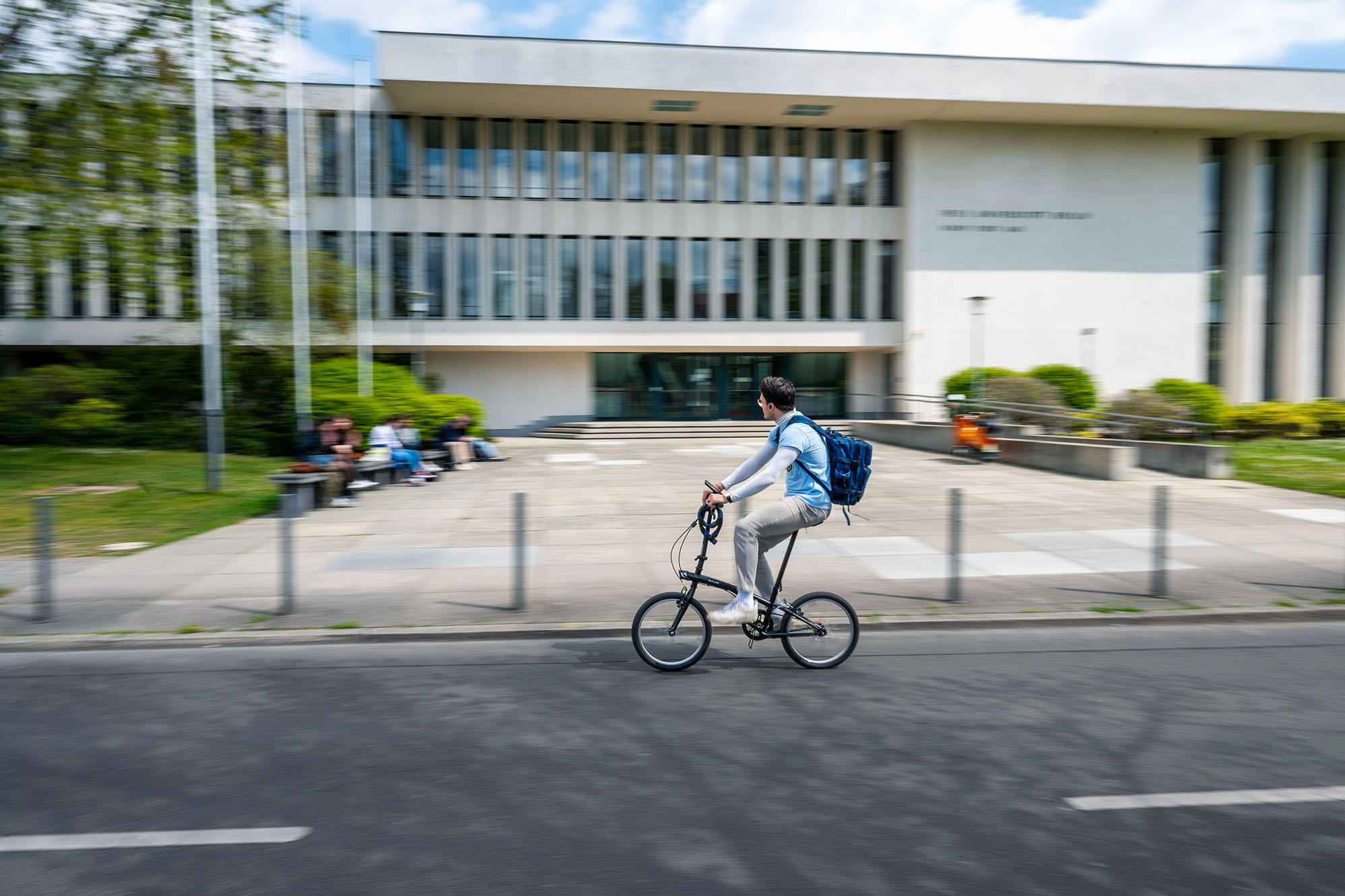 ein Fahrradfahrer vor dem Gebäude der Universitätsbibliothek der Freien Universität Berlin