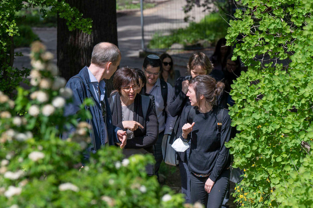 Teilnehmende der Trainingswoche im Gespräch beim Spaziergang durch den Botanischen Garten