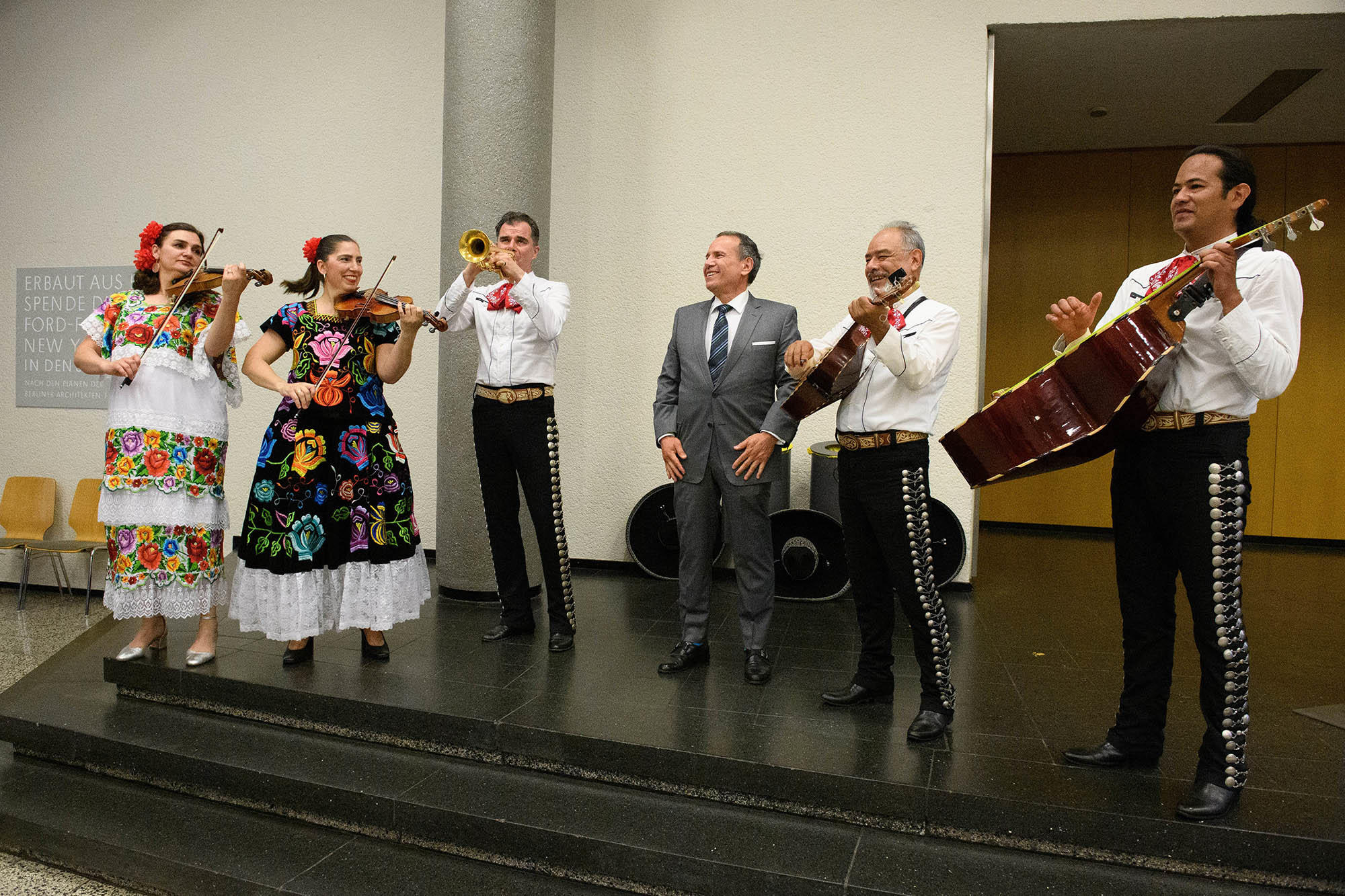 Mariachi-Band mit zwei Frauen und drei Männern in traditioneller Kleidung auf der Bühne