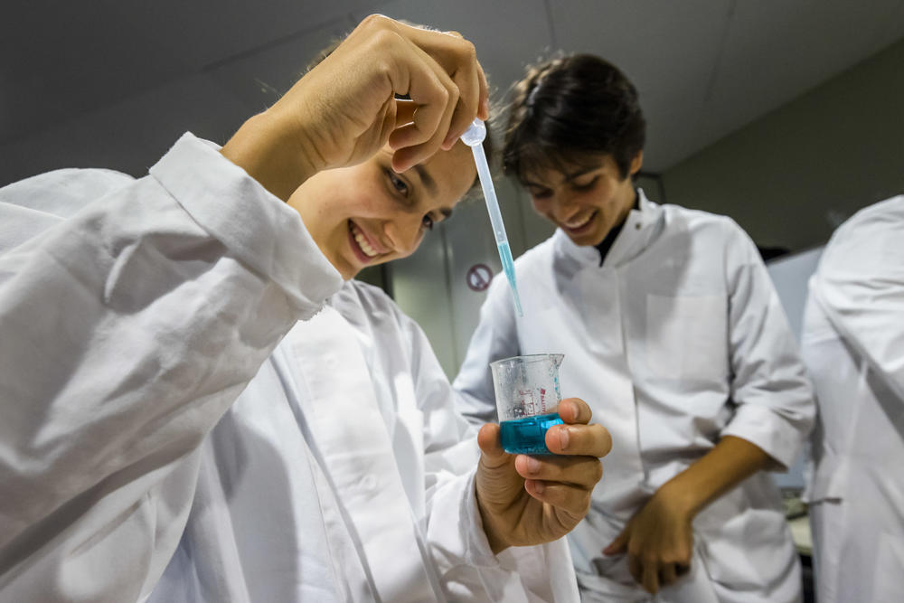 Mit Pipette und Becherglas: Kinder beim Stand der Pharmazie.