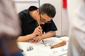 Kunst des schönen Schreibens: Am Ostasiatischen Seminar konnten Besucher*innen ihre Namen ins Chinesische übertragen lassen und selbst zu Pinsel und Tusche greifen.