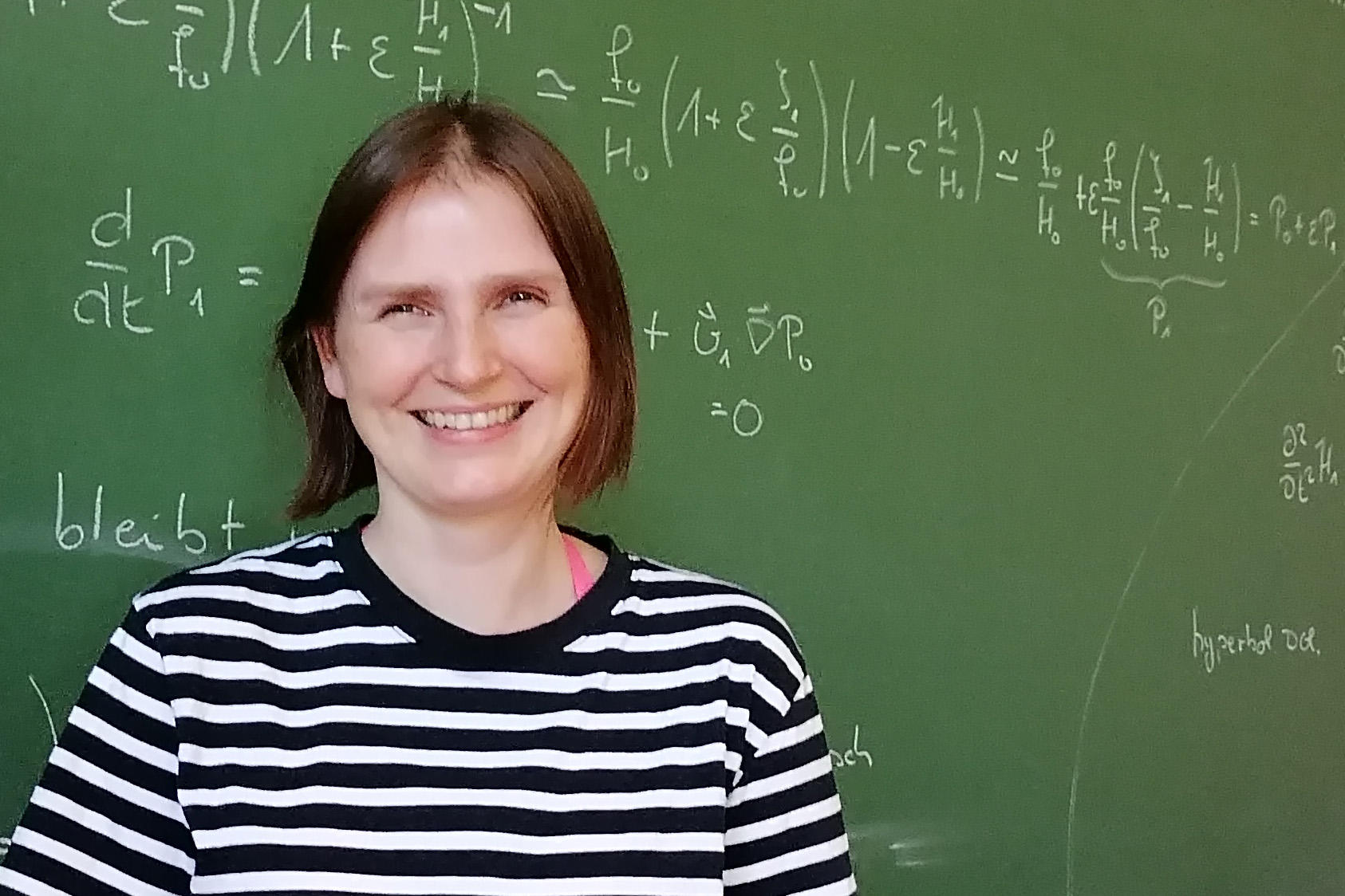 Porträtfoto von Lisa Schliecke vor einer beschriebenen Tafel