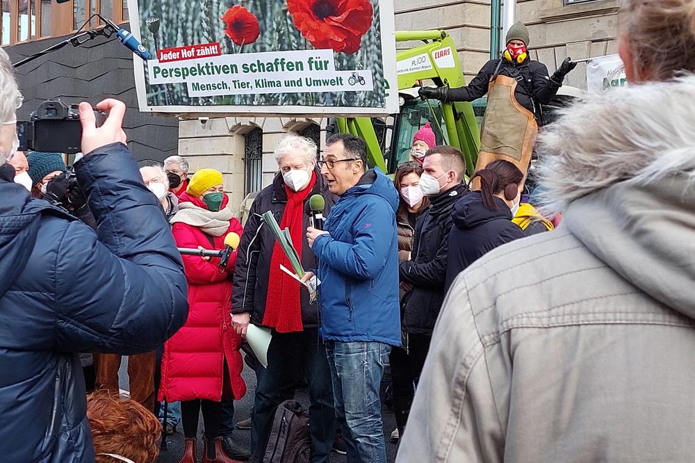 Seit 2011 finden die „Wir sind satt“-Demonstrationen statt. Cem Özdemir (mit Lauch und Mikrofon) ist der erste Landwirtschaftsminister, der sich den Protestierenden stellt.