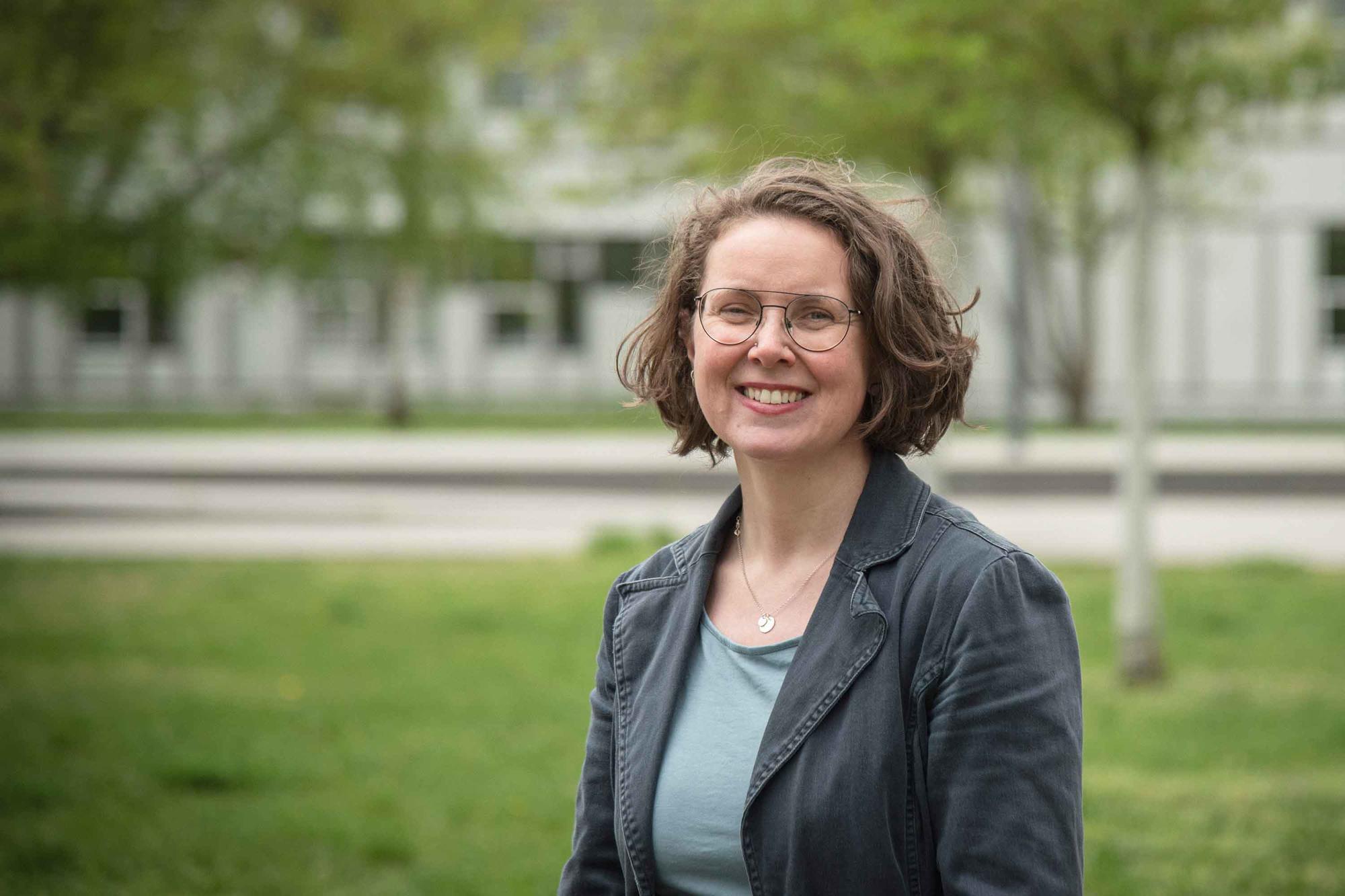 Porträtfoto der Biologin Fanny Langerwisch vor einem Gebäude der Freien Universität Berlin