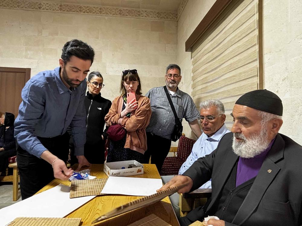 Lukas Aktaş (links) mit seinem Großvater (rechts). Der Kalligraph schreibt auf Syrisch-Aramäisch, der Liturgiesprache der syrischen Kirchen.