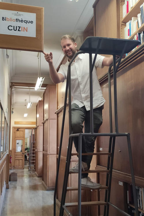 Die Faszination für Bücher verbindet Bibliotheksmitarbeitende überall auf der Welt. Das Bild zeigt Matheo Mareski-Iffländer vor der Bibliothèque Cuzin.