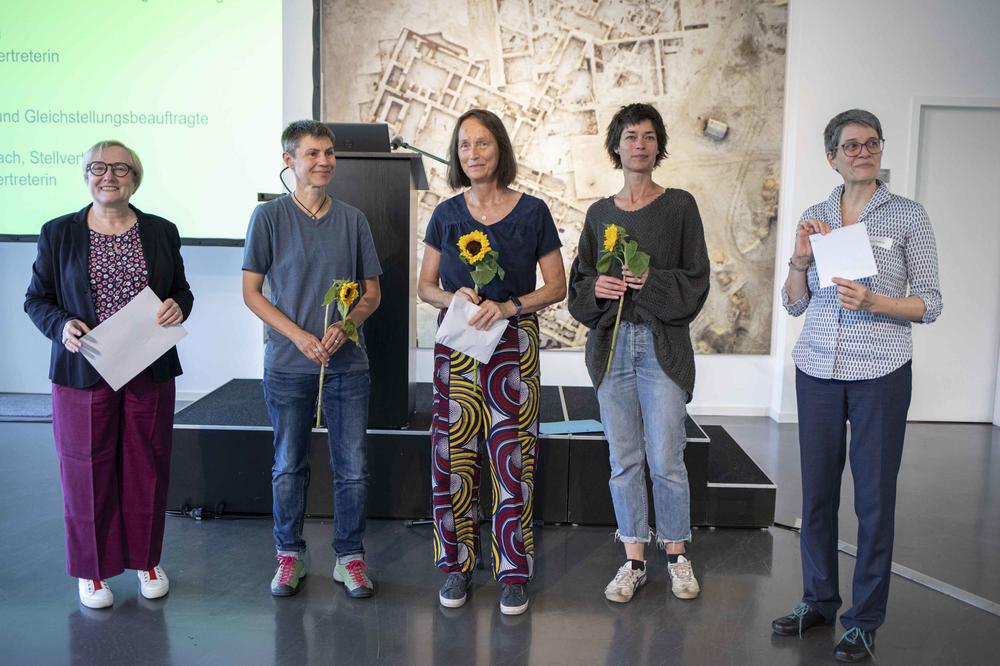 Mit Sonnenblumen begrüßt: Die Frauen- und Gleichstellungsbeauftragten am FB Mathematik und Informatik. V.l.n.r.: Verena Blechinger-Talcott, Sera Renée Zentiks, Christine Scharlach (Stv.), Maren-Wanda Wolf (Stv.), Corinna Tomberger.