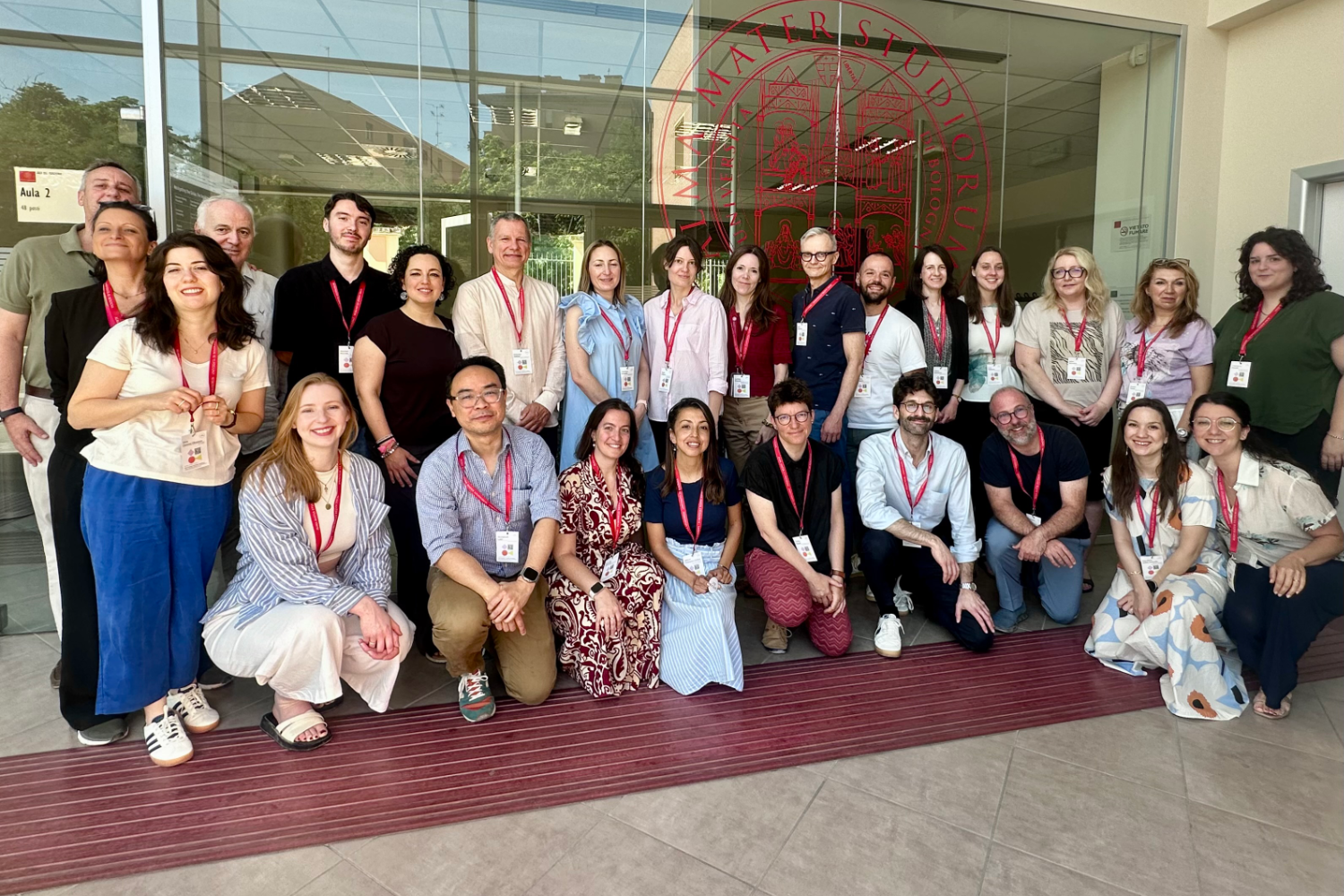 Participants of the Bologna staff training academy pose for a group photo in front of a building at the University of Bologna.