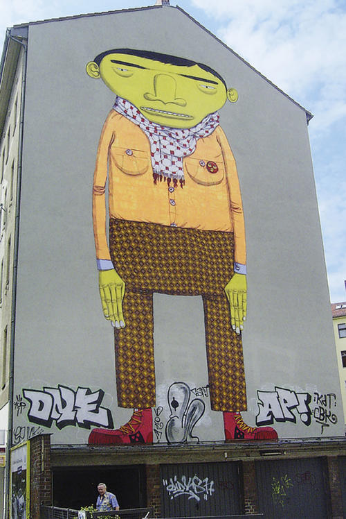 Hinter dem Namen Osgemeos verbergen sich die Künstler und Zwillingsbrüder Otavio and Gustavo Pandolfo, die auch schon in Berlin Kreuzberg eine Häuserwand verschönerten.