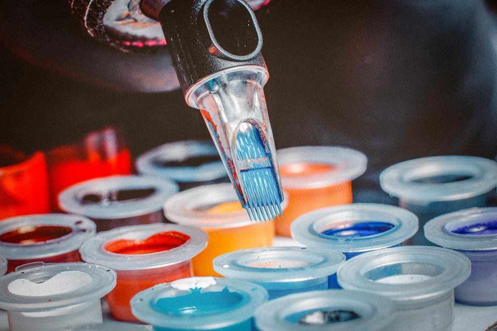 Das geht unter die Haut. Die Nadeln einer Tattoo-Maschine werden vor dem Stechen in Farbtöpfe getaucht. Die Pigmente, die auch in die Lymphknoten wandern, enthalten giftige Stoffe wie Nickel oder Chrom.