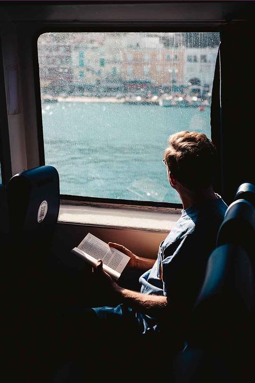Auf Reisen lesen und Gedanken schweifen lassen, ist ein Luxus, gerade auch in Zeiten, in denen Smartphones und deren Anwendungen unsere gesamte Aufmerksamkeit einzufordern scheinen: ein Reisender auf der Fähre von Capri nach Neapel.